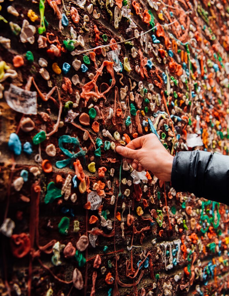 wall full of gum with person adding